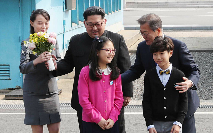 Theo Sputnik, bà Kim Yo-jong được coi là một nhân vật chính trị quyền lực ở Triều Tiên và là “cánh tay phải” bên cạnh nhà lãnh đạo Triều Tiên Kim Jong-un, tháp tùng ông Kim trong nhiều cuộc họp cấp cao, bao gồm Hội nghị thượng đỉnh với Tổng thống Mỹ Donald Trump và Tổng thống Hàn Quốc Moon Jae-in. Ảnh: Bà Kim Yo-jong (trái) cầm bó hoa khi nhà lãnh đạo Triều Tiên Kim Jong-un và Tổng thống Hàn Quốc Moon Jae-in chụp ảnh với các em nhỏ trước cuộc gặp thượng đỉnh tại Bàn Môn Điếm ngày 27/4/2018.