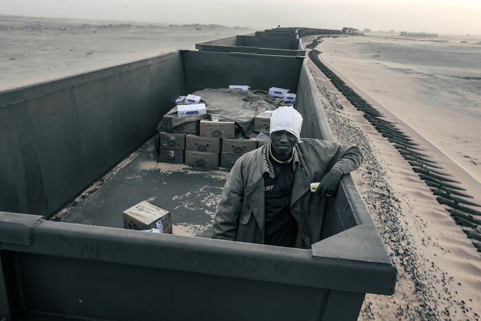 Người đàn ông Mauritania ngồi trong toa tàu chở quặng sắt di chuyển giữa Nouadhibou và Zouerat.