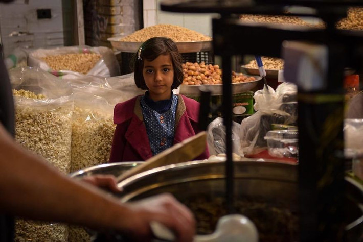 Một bé gái Iran đi mua kẹo.