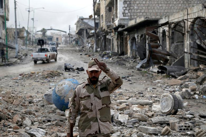 Một binh sĩ Syria đứng trên con đường ngổn ngang gạch đá hôm 30/1.