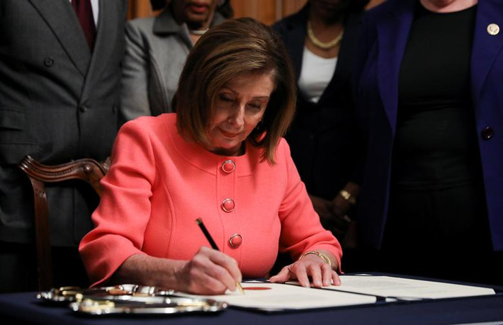 Bức ảnh chụp Chủ tịch Hạ viện Mỹ Nancy Pelosi ký hai điều khoản luận tội ông Trump trước khi chuyển chúng lên Thượng viện.