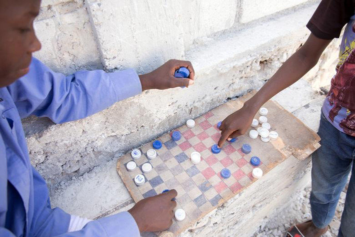 Những đứa trẻ chơi cờ bằng nắp chai nhựa ở Canaan, ngoại ô Port-au-Prince.