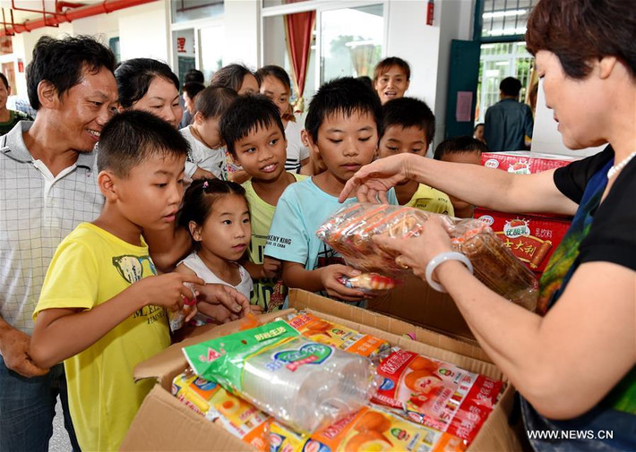 Một nhân viên phân phát thực phẩm cho người dân tại nơi tránh bão tạm thời trong một ngôi trường ở huyện Licheng ở Putian.