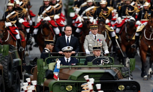 Tổng thống Pháp Francois Hollande (trung tâm) quan sát các binh sĩ khi đi xuống đại lộ Champs Elysees ở Paris trong buổi duyệt binh kỷ niệm ngày Quốc khánh Pháp.