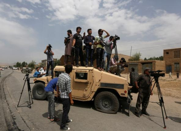 Các phóng viên đứng trên chiếc xe quân sự Humvee để ghi lại hình ảnh sau vụ đánh bom tự sát ở Kabul hôm 30/6.