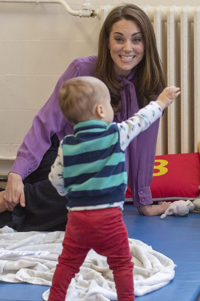 Công nương Kate Middleton chơi đùa với một em nhỏ tại trung tâm trẻ em Henry Fawcett ở London ngày 12/3.
