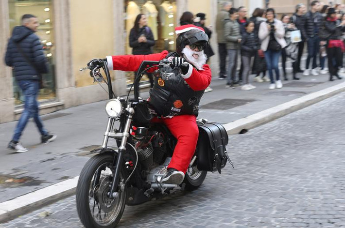 Người đàn ông mặc trang phục ông già Noel "cưỡi" mô tô trên đường phố Rome, Italy, hôm 22/12.