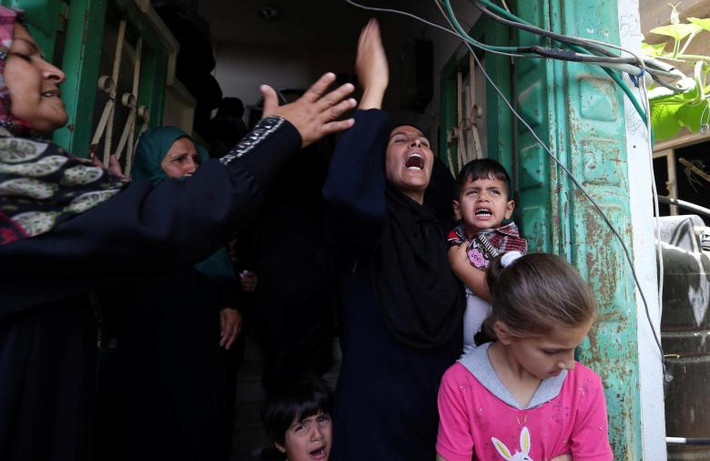 Những người phụ nữ và em nhỏ gào khóc trong đám tang của một người Palestine thiệt mạng trong cuộc đụng độ với lực lượng an ninh Israel ở phía nam Dải Gaza.