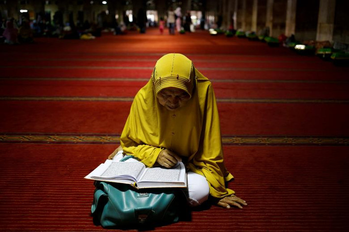 Một phụ nữ Hồi giáo đọc Kinh Koran trong lúc chờ bữa Iftar tại Nhà thờ Hồi giáo Istiqlal ở thủ đô Jakarta, Indonesia, ngày 19/5.