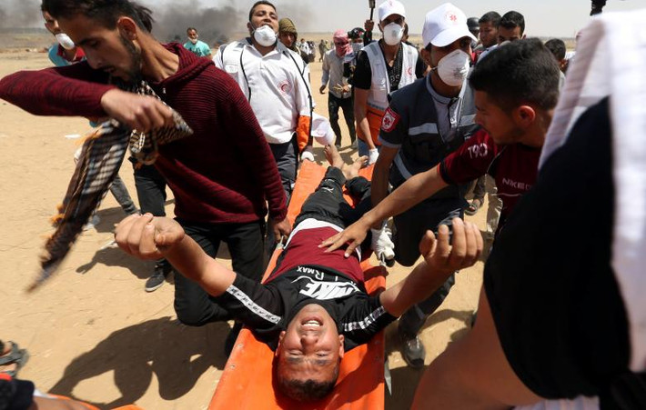 Một người biểu tình bị thương được đưa ra khỏi khu vực xung đột giữa Israel và Palestine.
