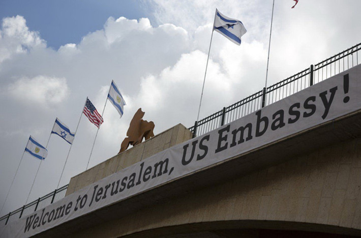Tấm biển có dòng chữ với nội dung "Chào mừng tới Jerusalem, Đại sứ quán Mỹ!" xuất hiện trên một tòa nhà có treo cờ Mỹ và Israel. Ảnh: Reuters.