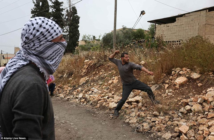 Người biểu tình Palestine ném đá về phía binh sĩ Israel trong cuộc đụng độ ở làng Kufr Qadoom gần thành phố Nablus, Bờ Tây.