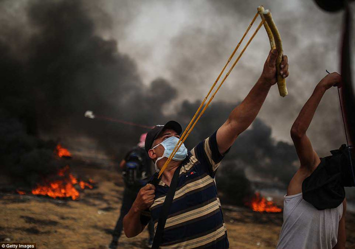 Một số người Palestine dùng nỏ bắn đá về phía lực lượng an ninh Israel.