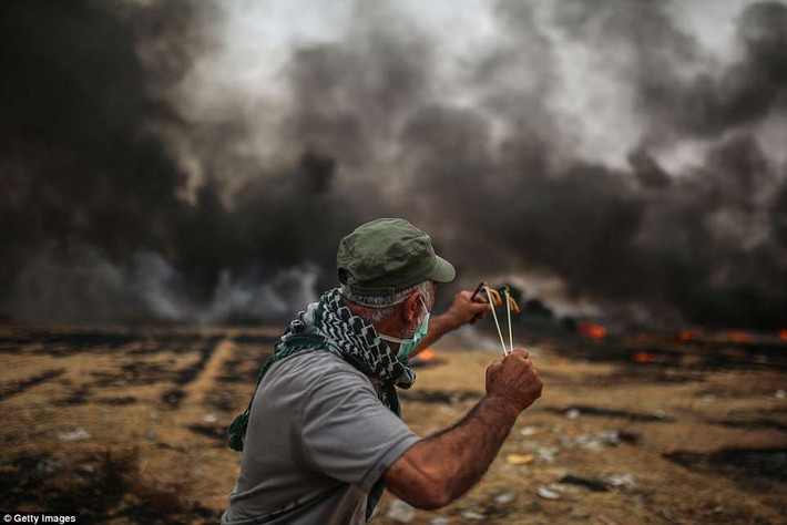 Một người biểu tình Palestine đứng gần hàng rào biên giới Israel. Hiện chưa có thông tin về thương vong bên phía Israel.