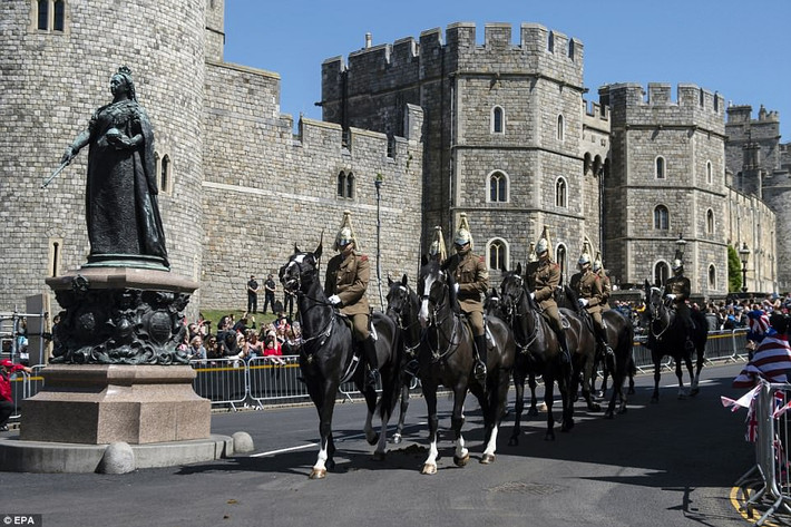 Đoàn diễu hành đi qua bức tượng Nữ hoàng Victoria ở trung tâm thị trấn và phía sau là Lâu đài Windsor.