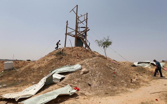 Người dân Palestine kiểm tra một chốt quan sát sau khi nơi này bị pháo kích ở phía nam Dải Gaza.