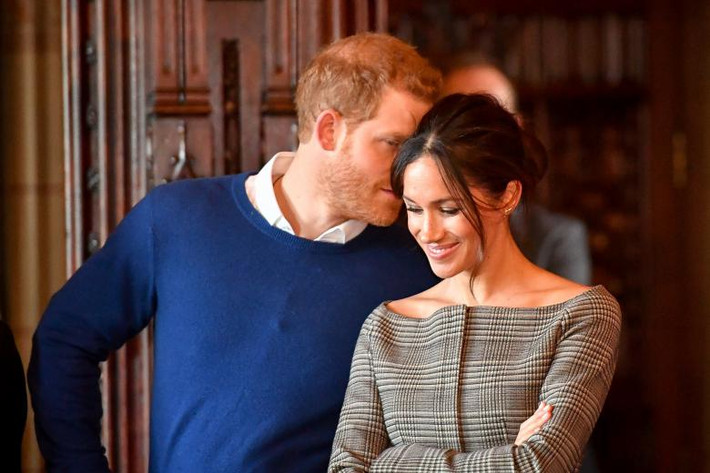 Hoàng tử Anh thì thầm với vợ chưa cưới Meghan khi xem một buổi biểu diễn trong chuyến thăm lâu đài Cardiff ở Cardiff ngày 18/1/2018.