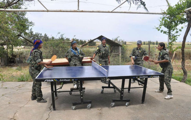 Các nữ binh người Kurd thuộc Đơn vị bảo vệ phụ nữ (YPJ) chơi bóng bàn trong thời gian giải trí ở gần thành phố Qamishli ngày 11/5/2014.