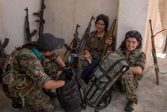 Các nữ chiến binh người Kurd thuộc lực lượng YPG nói chuyện với nhau ở làng Tel Nasri, phía tây thị trấn Tel Tamr, sau khi YPG tuyên bố họ đã giành quyền kiểm soát khu vực này từ tay phiến quân IS ngày 21/5/2015.