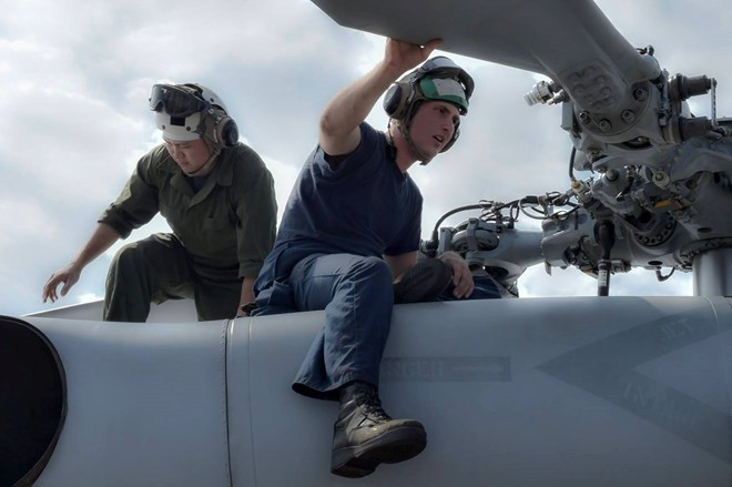Hai kỹ thuật viên kiểm tra trực thăng MH-60R chuẩn bị cho sứ mệnh tuần tra trên Biển Đông.