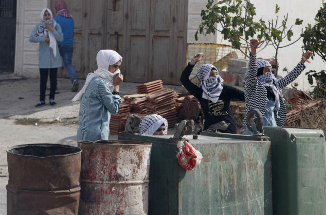Các cô gái Palestine ném đá trong cuộc đụng độ với người Israel ở thành phố Hebron, Bờ Tây.