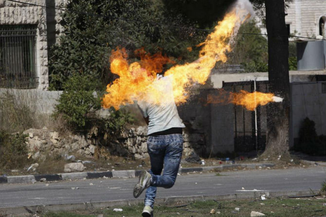 Một người biểu tình Palestine ném bom xăng vào các binh sĩ Israel trong cuộc đụng độ dữ dội tại thành phố Hebron, Bờ Tây ngày 13/10/2015.