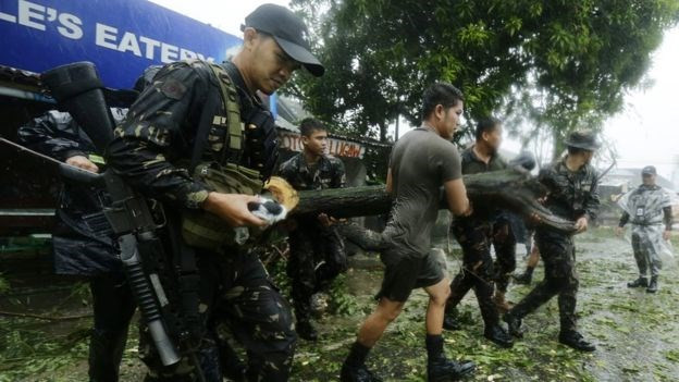 Binh sĩ Philippines lôi các cây đổ để dọn đường sau ảnh hưởng của bão.