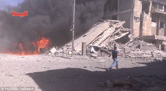 Các tòa nhà sụp đổ và đám cháy sau khi máy bay Nga không kích ở tỉnh Homs, miền Trung Syria, hôm 30/9. Ảnh: RT