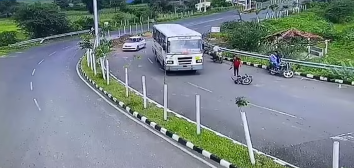 Một vài giây sau khi ngã vào gầm xe buýt, người điều khiển xe máy được nhìn thấy tự bò ra khỏi gầm xe.