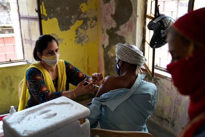 Nhân viên y tế tiêm vắc xin ngừa COVID-19 cho người dân ở làng Nizampur, ngoại ô New Delhi.