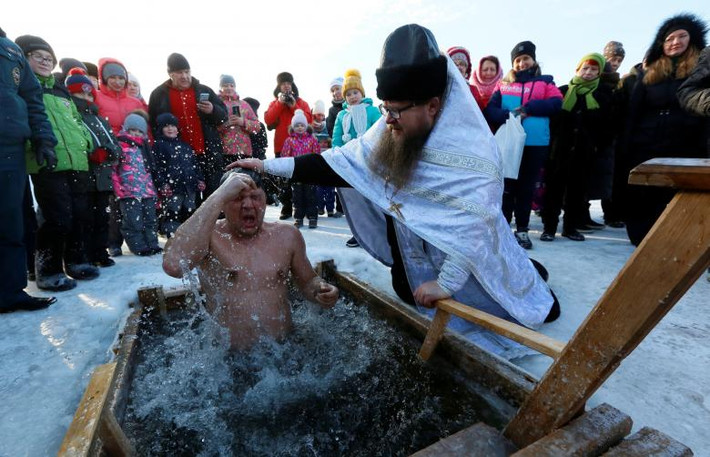 Một người đàn ông ngâm mình trong làn nước lạnh giá ở hồ Buzim, phía bắc Krasnoyarsk, Nga, ngày 19/1.