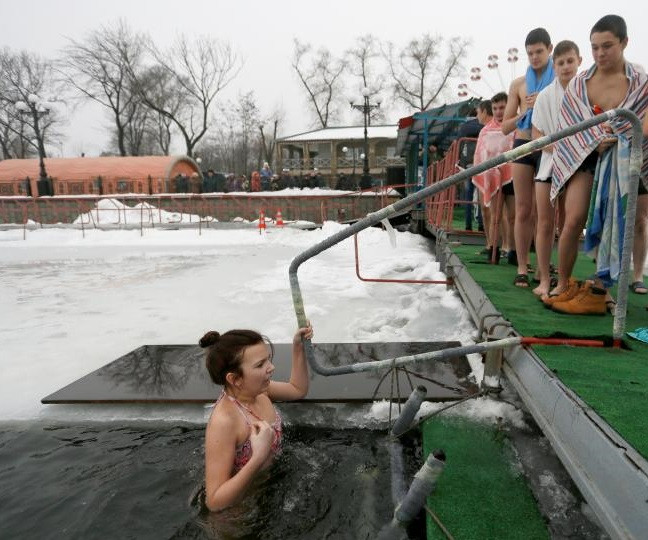 Mọi người xếp hàng để xuống hồ nước ở thành phố Donetsk, miền đông Ukraine, ngày 19/1 trong dịp mừng Lễ Hiển Linh.