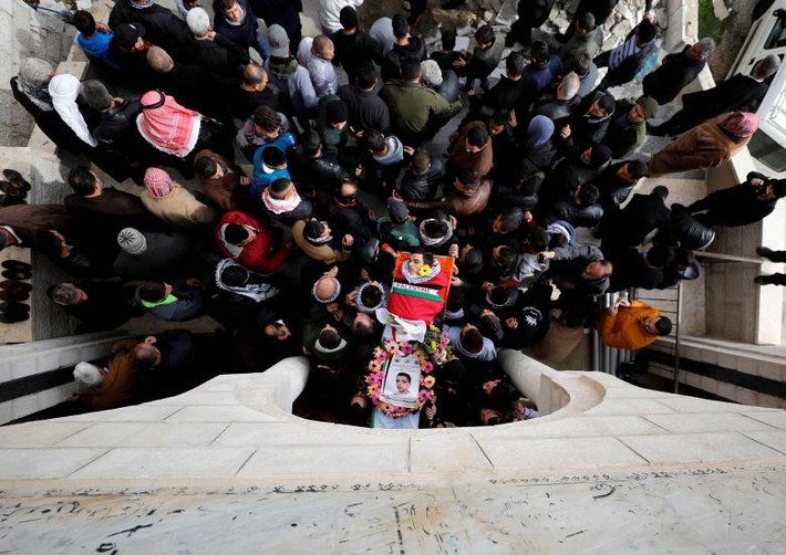 Người dân khiêng quan tài chứa thi thể của Mosab al-Tamini, một thiếu niên Palestine 17 tuổi đã thiệt mạng trong vụ ẩu đã giữa binh sĩ Israel và người biểu tình Palestine, trong lễ tang gần thành phố Ramallah ngày 4/1.