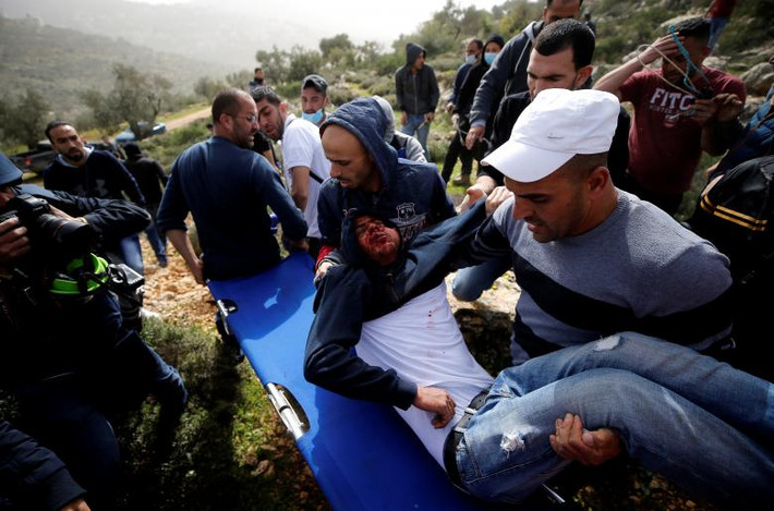 Một người Palestine bị thương được đưa ra khỏi khu vực xung đột gần Ramallah ngày 16/2.