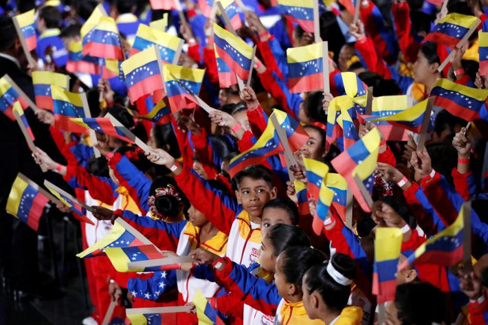 Các em nhỏ vẫy cờ trước lễ tuyên thệ nhậm chức của Tổng thống Venezuela Maduro ở Caracas.
