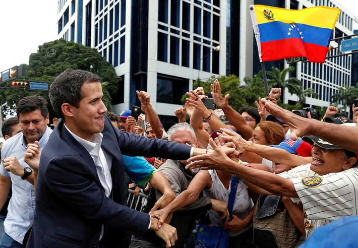 Ông Guaido bắt tay những người ủng hộ trong cuộc biểu tình phản đối chính quyền của Tổng thống Maduro ở Caracas ngày 23/1. Ảnh: Reuters.