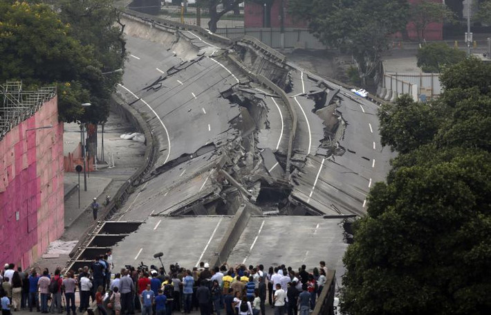 Người dân đứng nhìn cây cầu vượt Perimetral sau khi nó bị phá hủy một phần ở Rio de Janeiro, Brazil, hồi tháng 4/2014.