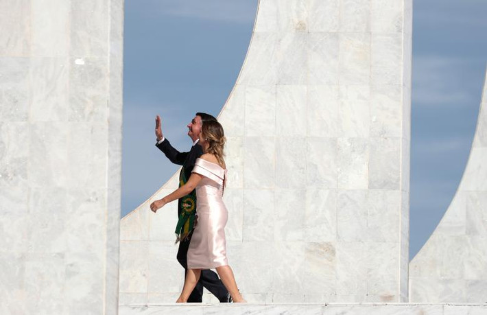 Tổng thống Bolsonaro và phu nhân Michelle Bolsonaro vẫy chào đám đông người ủng hộ tại Dinh Planalto.