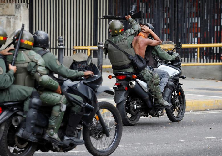 Lực lượng Vệ binh Quốc gia Venezuela bắt giữ một người biểu tình chống chính quyền của Tổng thống Maduro ngày 23/1.