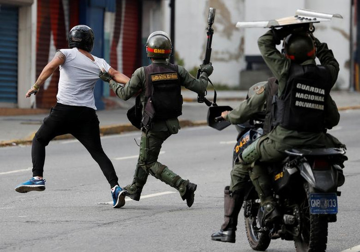 Lực lượng an ninh Venezuela đuổi theo một người biểu tình chống chính phủ của ông Maduro ở thủ đô Caracas ngày 23/1.