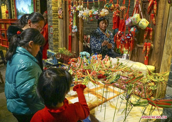 Các em nhỏ đứng trước gian hàng đồ thủ công tại trong một khu phố ẩm thực và văn hoá ở Đường Sơn, tỉnh Hà Bắc, ngày 26/1.