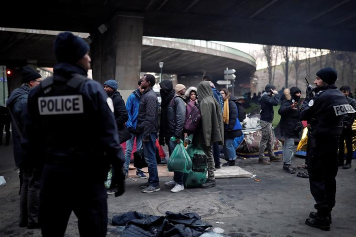 Các di dân xếp hàng chờ lên xe để được đưa tới nơi khác tại thủ đô Paris.