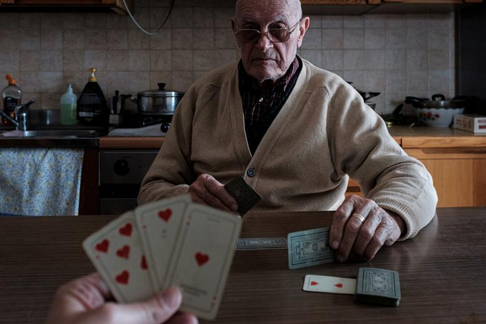 Marzio Toniolo chơi bài cùng ông Gino Verani, 87 tuổi, tại nhà hôm 12/3/2020.