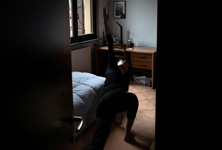 Chiara Zuddas, 32 tuổi, tập yoga ở phòng ngủ trong thời gian tự cách ly.