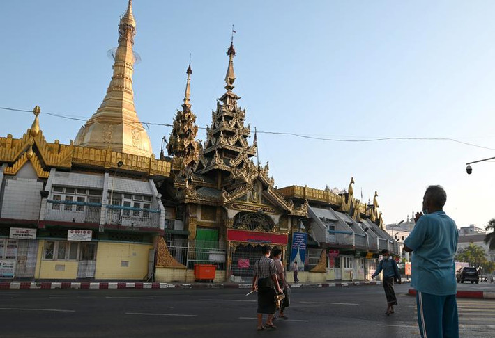 Người đàn ông cầu nguyện trước chùa Sule ở Yangon vào sáng sớm 1/2.