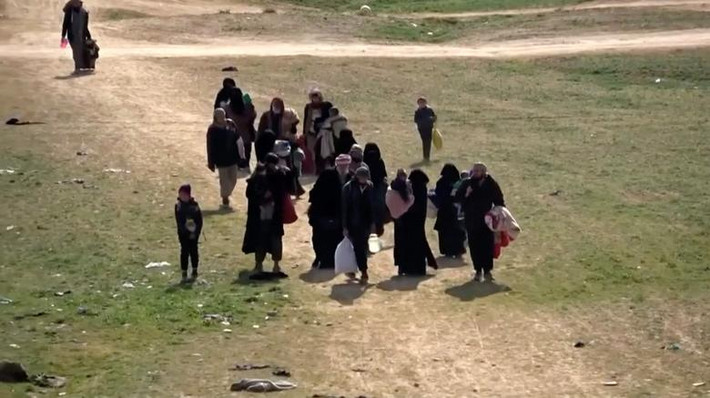 Những người dân sơ tán đi qua cánh đồng gần Baghouz, tỉnh Deir Ezzor, ngày 10/2.