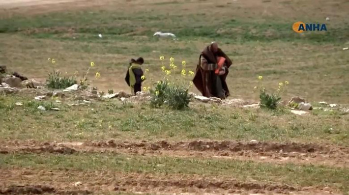 Người dân mang theo đồ đạc đi qua cánh đồng gần Baghouz, tỉnh Deir Ezzor, ngày 10/2.