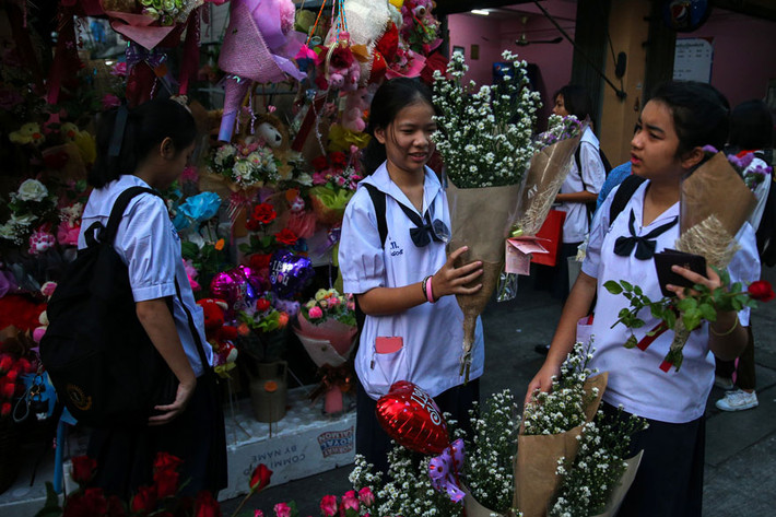 Các em học sinh mua hoa ở thủ đô Bangkok, Thái Lan. Ảnh: Reuters.