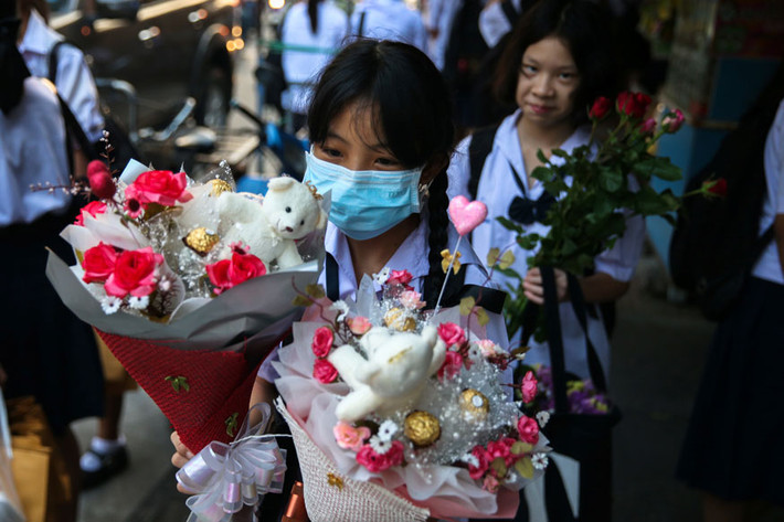 Các em học sinh cầm những bó hoa ở thủ đô Bangkok. Ảnh: Reuters.