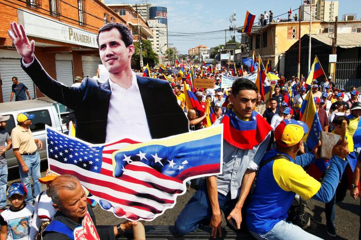 Theo hãng thông tấn Reuters, những người ủng hộ thủ lĩnh phe đối lập Juan Guaido, cũng như đương kim Tổng thống Venezuela Nicolas Maduro đã cùng nhau đổ ra đường phố trong một cuộc tuần hành có quy mô chưa từng có hôm 12/2. Ảnh: Những người ủng hộ phe đối lập mang theo bức hình của Chủ tịch Quốc hội Venezuela Juan Guaido tham gia vào cuộc tuần hành phản đối Tổng thống Maduro ở Maracaibo. (Nguồn ảnh: Reuters)